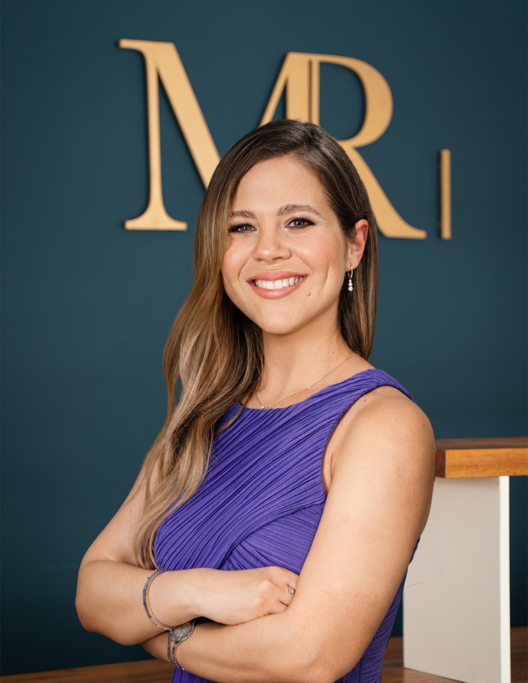 Retrato en las instalaciones de MR Médica, frente al logotipo de la clínica